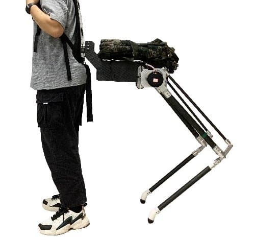 The physical Centaur prototype worn by a person, seen from the side: a back frame connects to a carbon-fibre robotic torso carrying a load, supported by two jointed robotic legs. The photo is cropped at the shoulders.